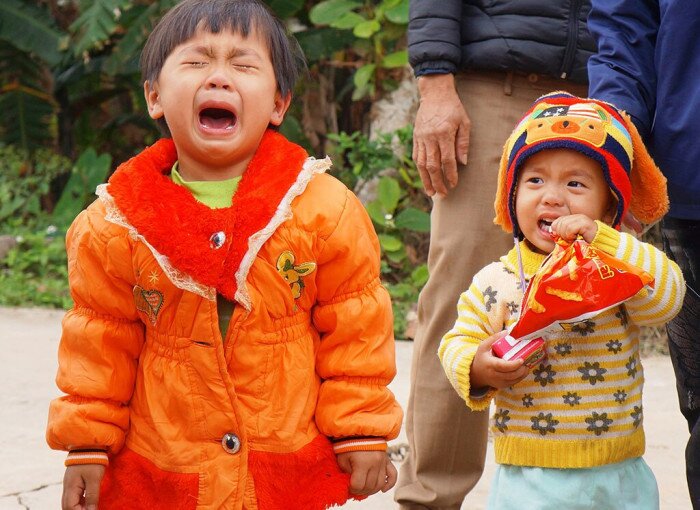 Hai đứa trẻ khóc lóc không chịu đội khăn tang (Ảnh: Báo Giao thông)