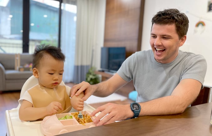 Anh John chuẩn bị đồ ăn cho con bữa tối 21/6. Cậu bé có lịch ăn cố định vào 18h và đi ngủ lúc 19h30 . Ảnh: Phan Dương.
