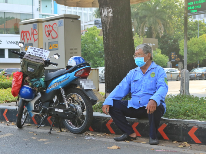 Ông Vinh ngồi bên vệ đường, cậy nhờ sự giúp đỡ của cộng đồng (Ảnh: Thanh Niên)