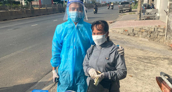 Chị Huệ đang phát tiền cho người dân trở về quê tránh dịch