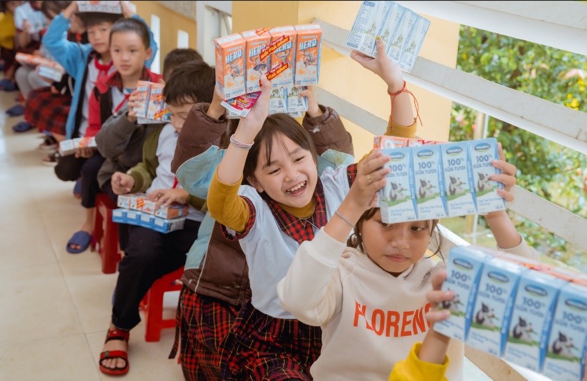 Các em học sinh tại Quảng Nam và Huế vui mừng khi nhận sữa Vinamilk từ đoàn hỗ trợ.