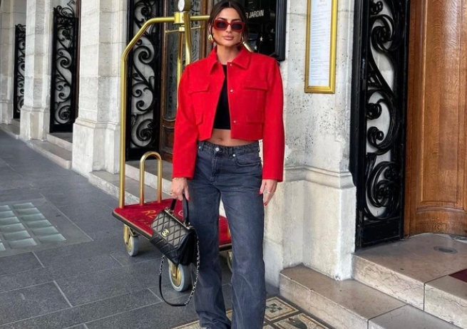 Áo khoác dáng ngắn khỏe khoắn màu đỏ tươi phối cùng crop top đen và quần suông denim làm nên vẻ ngoài thời thượng, vô cùng cá tính. Cô nàng này còn khéo kết lại bộ đồ cùng kính râm gọng đỏ, giày sneakers.    