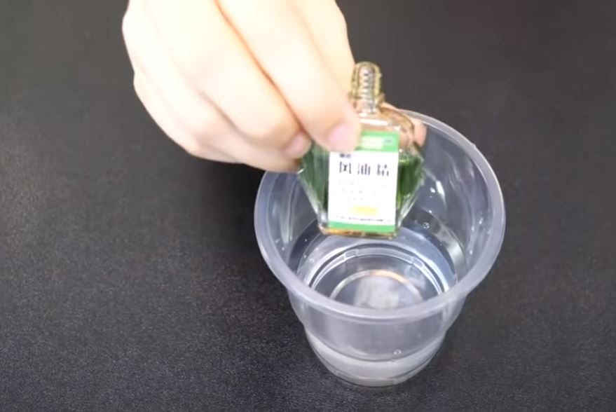 Thêm vài giọt dầu gió vào cốc giấm trắng.