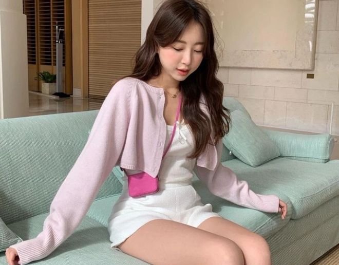 Cardigan dáng ngắn gây ấn tượng bởi vẻ ngoài trẻ trung. Bạn có thể học cô nàng Kim Minjung diện bộ đồ tông trắng gồm áo hai dây thắt nơ, quần shorts vải dạ và tạo điểm nhấn bằng áo cardigan màu hồng phớt ngọt ngào.