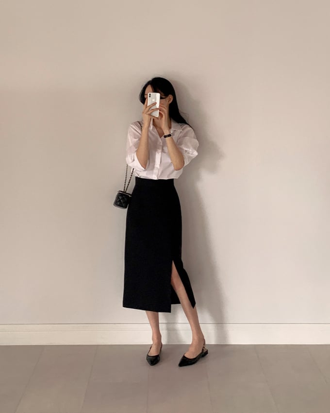 Áo sơ mi trắng và chân váy đen là công thức không bao giờ lỗi mốt nhưng để nổi bật các nàng hãy ưu tiên chân váy xẻ tà. Mẫu chân váy này rất thời thượng.