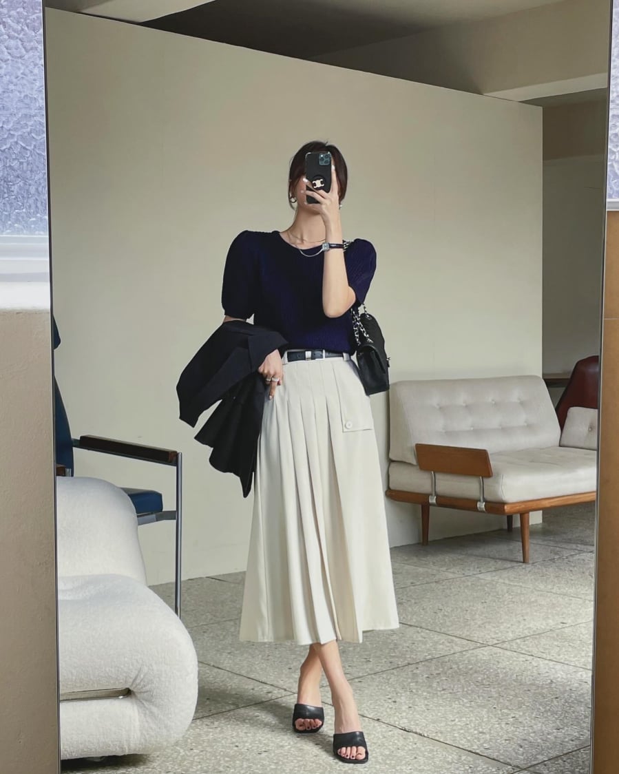 Áo len cộc tay mang tông màu xanh than trang nhã và sang trọng. Để không bị cộng tuổi khi diện áo len cộc tay tối màu, chị em nên kết hợp cùng chân váy trắng, ngoài ra có thể 