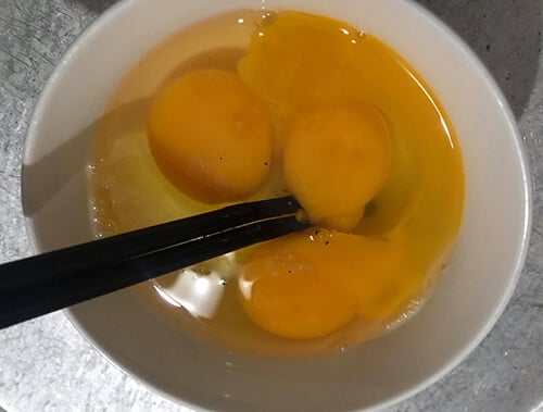 Đập trứng vào bát rồi khuấy đều.