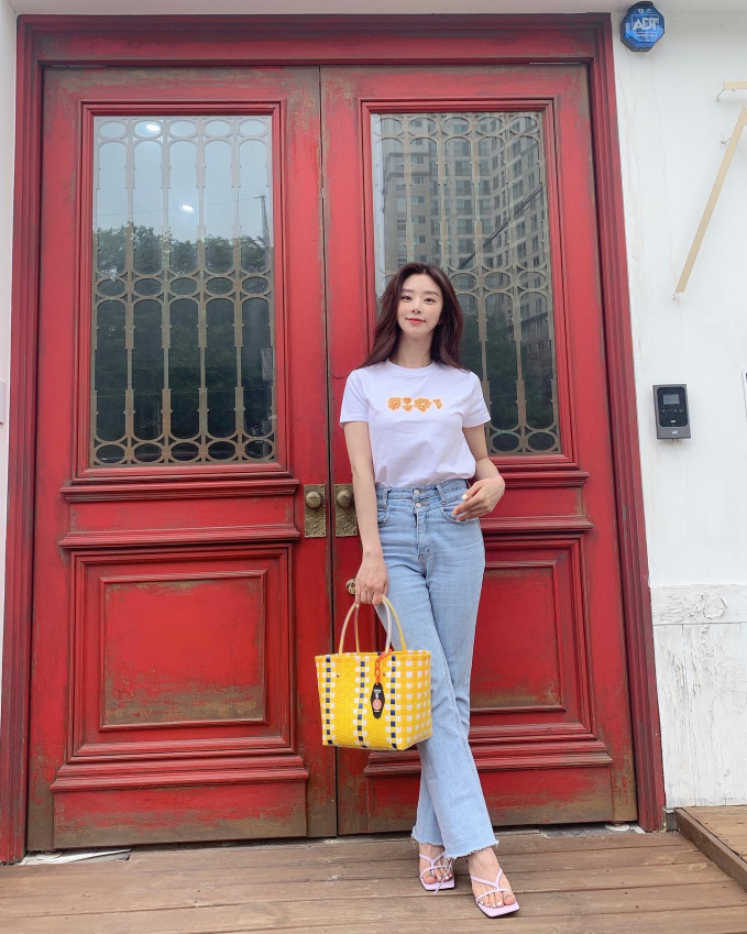 Áo thun trắng và quần jeans xanh cơ bản nhưng vẫn sẽ giúp bạn có được vẻ ngoài trẻ trung, thời thượng. Lee Joo Bin khéo léo tôn dáng bằng cách sơ vin gọn gàng, đi sandal cao gót quai mảnh sang chảnh.