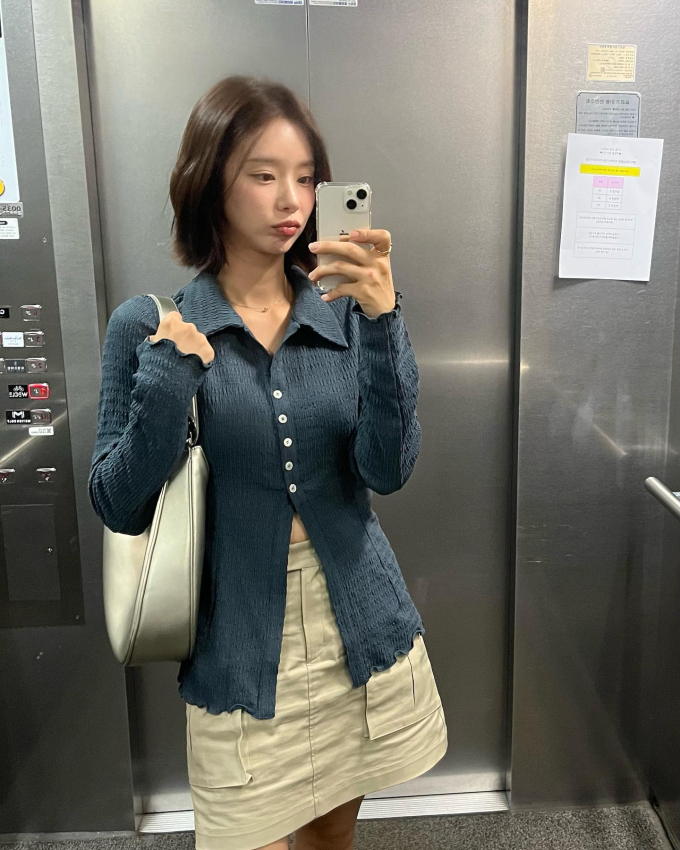Áo sơ mi xẻ tà sẽ mang đến làn gió mới cho phong cách của chị em. Lee Joo Bin kết hợp mẫu áo sơ mi phá cách này cùng chân váy màu be và ghi điểm ở sự trẻ trung.