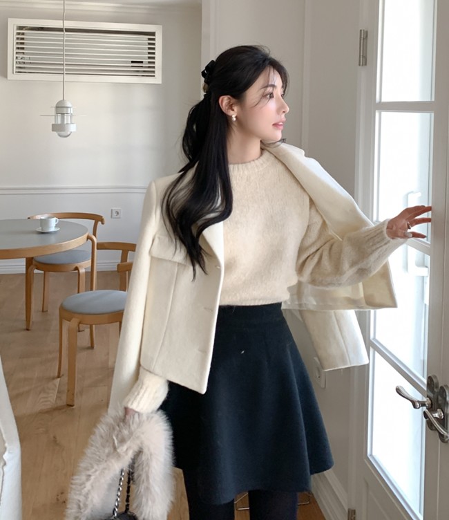 Áo len tối giản mix cùng chân váy tối màu, thêm áo khoác dạ dáng ngắn màu sáng chính là công thức giúp thăng hạng phong cách với skater skirt. 
