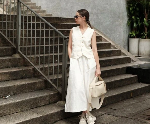 Ghi lại các chi tiết về diện mạo của bạn bằng cách mặc áo ghi lê cùng chân váy trắng. Đối với các phụ kiện đi kèm, không gì hoàn hảo hơn một chiếc túi xách nhỏ.