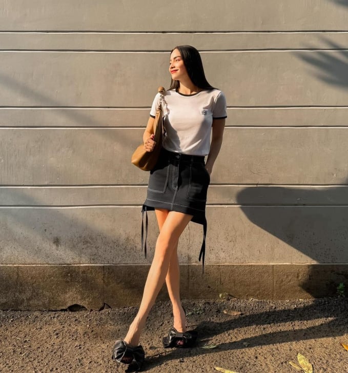 Áo thun trắng và chân váy denim màu đen và không quên sơ vin gọn gàng tăng điểm phong cách. Đôi giày nơ to bản rất nổi bật nhưng vẫn hài hòa với tổng thể Shbet999 com đăng nhập màu trung tính.