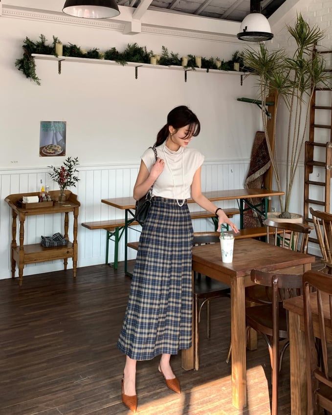 Để tạo điểm nhấn nổi bật cho phong cách, chị em đừng bỏ qua chân váy chữ A họa tiết kẻ. Món thời trang này phảng phất nét cổ điển và không bao giờ lỗi mốt. Tổng thể outfit trở nên sang trọng hơn nhờ đôi giày mũi nhọn, vòng cổ ngọc trai.    