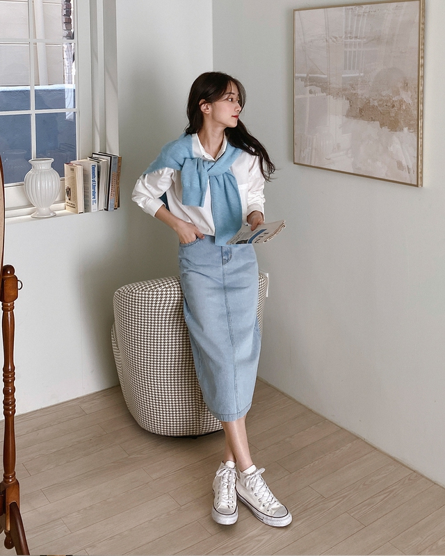 Áo sơ mi trắng và chân váy denim là sự kết hợp quen thuộc nhưng không bao giờ gây nhàm chán. Có thể thêm áo len quàng vai, rồi hoàn thiện outfit bằng đôi sneaker trắng năng động.    