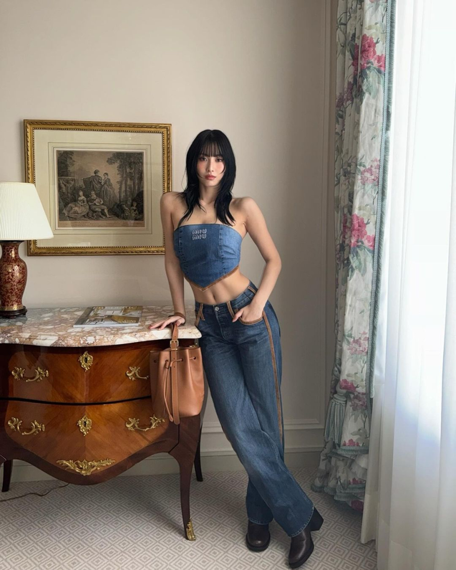 Momo (TWICE) nhấn mạnh thần thái gợi cảm khi để lộ bờ vai tuyệt mỹ và cơ bụng săn chắc trong chiếc áo crop top có thiết kế dáng khăn choàng quyến rũ, tạo nên một chỉnh thể hoàn hảo. Bản phối của cô nàng khi tham dự buổi trình diễn của Miu Miu là một ví dụ tuyệt vời về thời trang denim đơn giản nhưng sang trọng.    