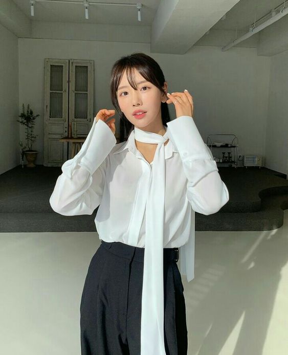 Các cô nàng mê style của các nữ chính phim Hàn chắc hẳn không xa lạ với áo sơ mi buộc dây cổ hờ hững. 