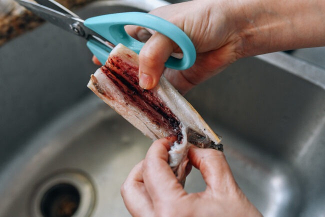 Trước tiên, hãy xử lý cá. Cạo bỏ lớp ngoài màu bạc ở cá hố.