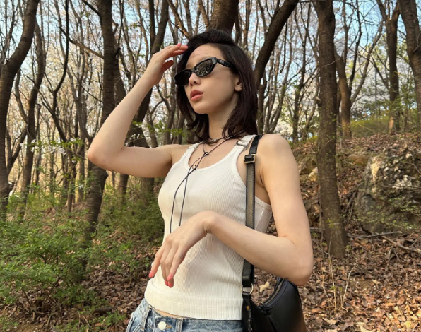 Đơn giản nhưng luôn chuẩn mốt là ưu điểm của set áo tank top trắng và quần jeans xanh. Túi xách màu đen và mắt kính góp phần tăng độ 