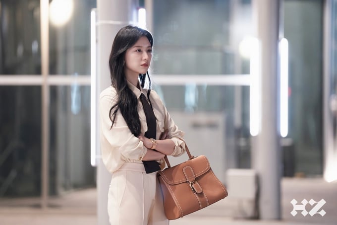 Diện một set áo sơ mi màu trung tính, Kim Ji Won mix cùng quần âu có đường ly giữa, Kim Ji Won đã tô điểm cà vạt, túi xách tông màu nâu. Sơ vin là thao tác không thể thiếu để hoàn thiện những outfit sang trọng, chỉn chu.    
