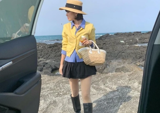 Mix áo cadigan màu vàng khoác ngoài sơ mi kẻ xanh. Khi đi chơi, các nàng tha hồ lựa chọn những thiết kế tươi vui một chút. Túi cói và bốt cao cổ là những món đồ được Hyami lựa chọn để kết lại bản phối.