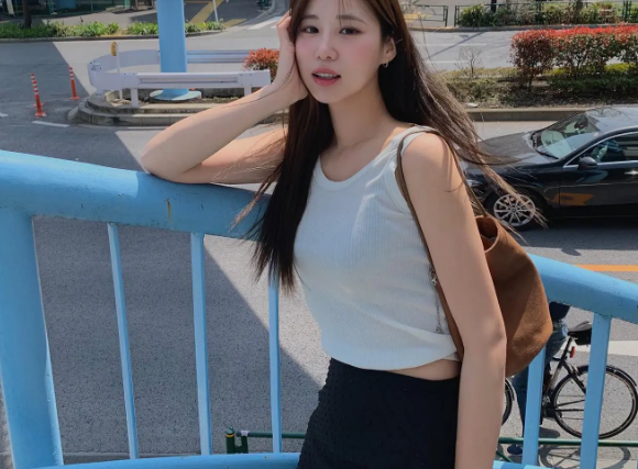 Chỉ đơn giản là kết hợp áo tank top trắng với chân váy đen, các nàng sẽ có ngay vẻ ngoài sành điệu, nữ tính và rất ăn ảnh. Thiết kế áo tank top dáng lửng còn mang đến hiệu quả 