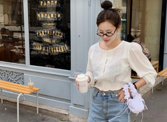Quần denim short kết hợp với áo trắng là combo hoàn hảo giúp nàng trẻ ra vài tuổi. Công thức diện đồ này giúp vẻ ngoài trở nên nữ tính, yêu kiều hơn. Nếu ưu tiên áo blouse dáng lửng, người mặc không cần sơ vin mà tổng thể trông vẫn cao ráo.    