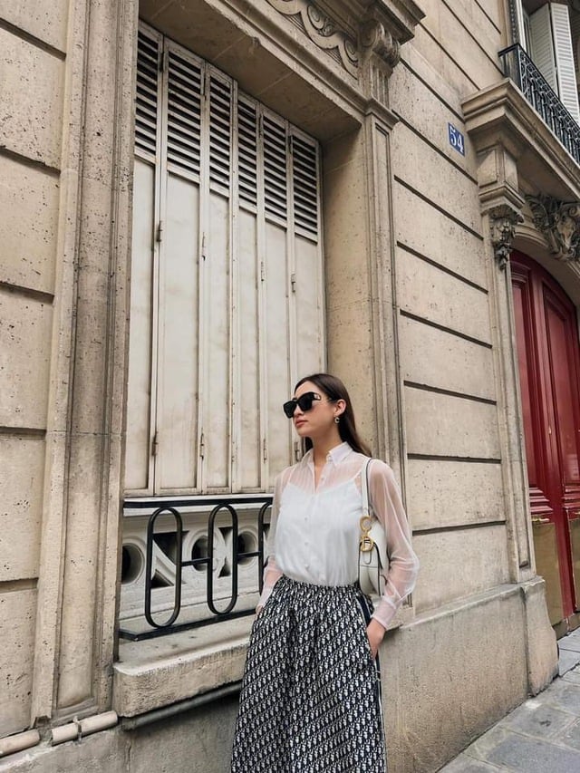 Những chiếc áo sơ mi xuyên thấu đang là item được lăng xê mạnh mẽ. Món đồ tưởng hở hang này thực chất lại vừa thanh lịch, vừa trẻ trung này. Cô kết hợp mẫu áo cùng chân váy dài thướt tha nhẹ nhàng không hề phản cảm.     