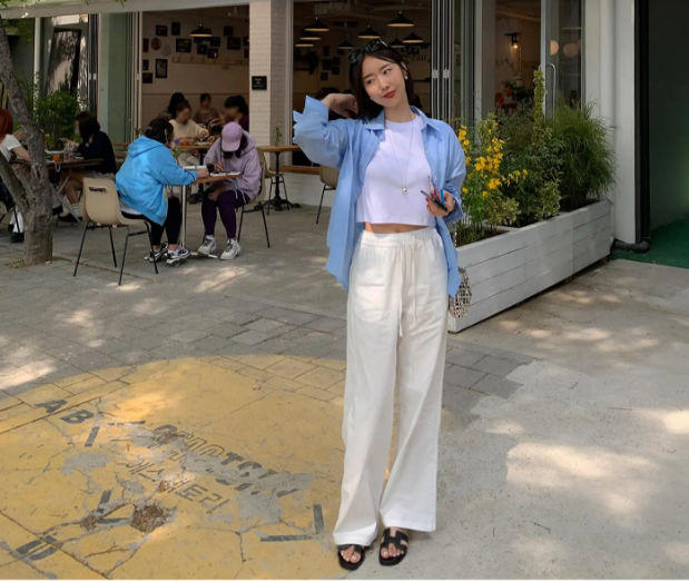 Đừng bỏ qua set áo thun dáng lửng kết hợp với quần vải thô, cùng tông màu trắng. Mẫu áo sơ mi màu pastel khoác ngoài giúp tăng thêm sự hack tuổi.     