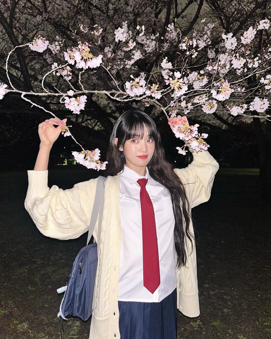 Minnie (G-Idle) diện bản phối đồng phục dễ thương và đậm chất thanh xuân. Sự đối lập màu sắc của chiếc cà vạt đỏ và chân váy xanh tạo nên sức hút khó cưỡng. Nữ ca sĩ còn lựa chọn phối thêm cùng chiếc cardigan màu kem tươi tắn đầy phong cách.     