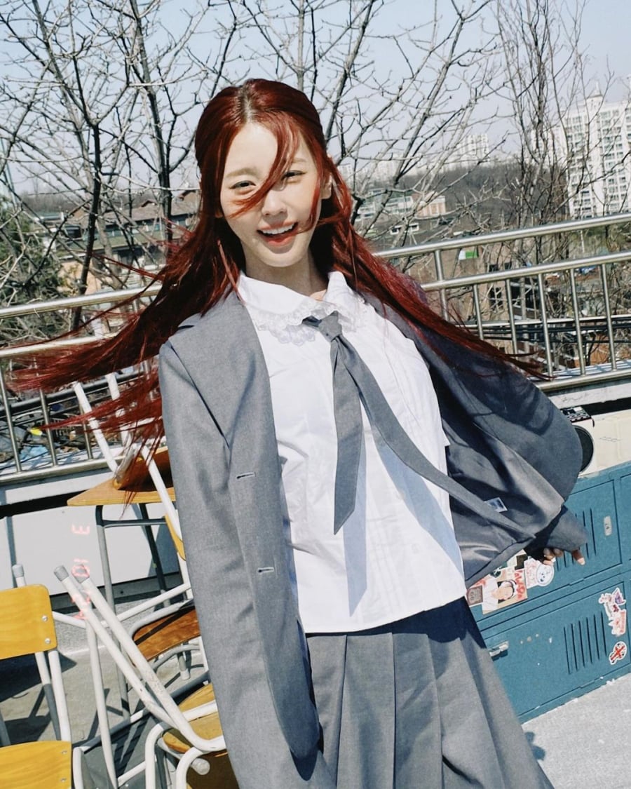 Miyeon (G-Idle) diện đồng phục học sinh với tông màu xám trendy chủ đạo. Chiếc váy với những đường xếp tinh tế, có chiều dài quá gối làm tôn vinh vẻ đẹp ngây ngô. Á vest khoác ngoài trông có vẻ dường như quá khổ so với Miyeon nhưng lại góp phần mang đến vẻ đáng yêu và tinh nghịch.    