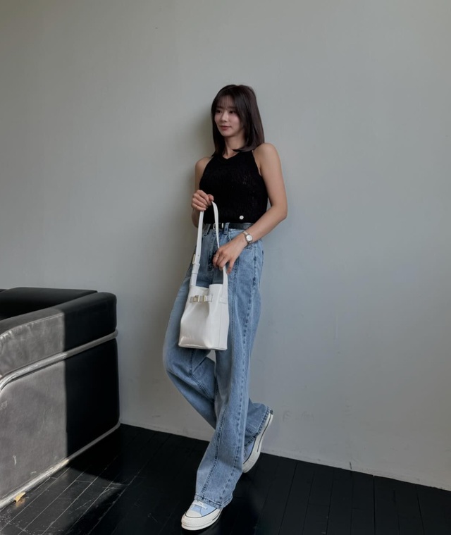 Công thức áo gile màu đen và quần jeans xanh không hề cầu kỳ,  thắt lưng da là chi tiết quan trọng giúp nâng tầm outfit. Đôi sneaker màu pastel rất phù hợp với bộ cánh năng động, trẻ trung.    