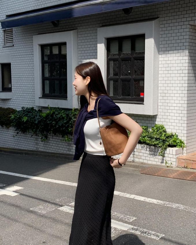 Công thức áo tank top trắng và chân váy đen sẽ giúp người mặc có được outfit nữ tính, đẹp mắt mà không tốn nhiều công sức.     