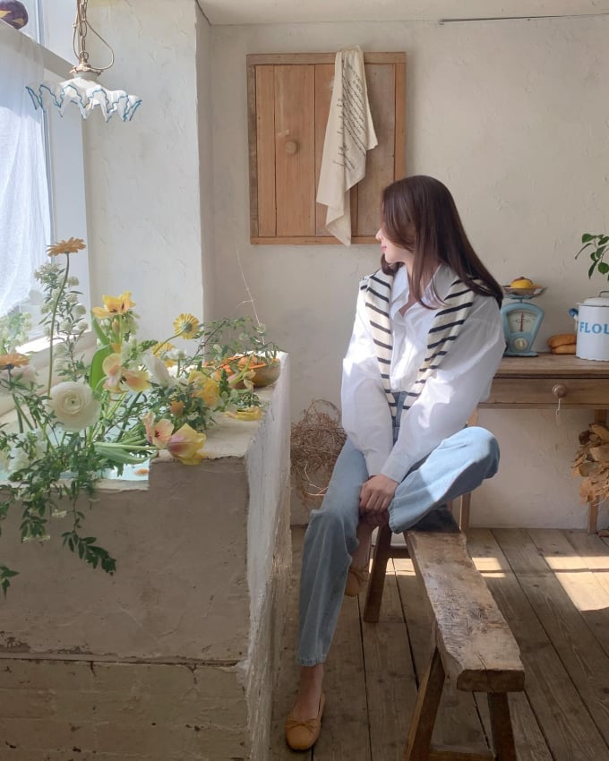Công thức áo sơ mi và quần jeans xanh quen thuộc sẽ trở nên nổi bật hơn khi được tô điểm chiếc áo kẻ quàng vai. Đôi giày búp bê đơn giản ăn nhập hoàn hảo.     