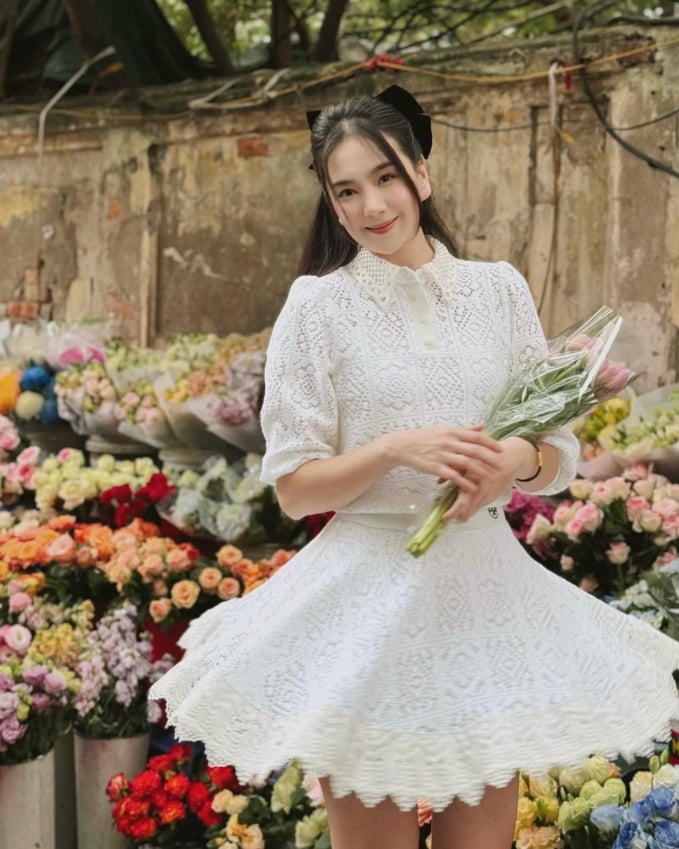 Áo trắng và chân váy mini đồng bộ của Mai Ngọc giúp cô trở nên thanh lich hơn.
