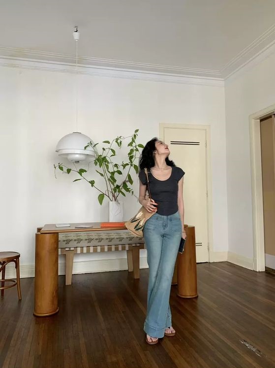Áo thun ôm dáng và quần jeans ống loe với tông màu trang nhã làm chủ đạo,