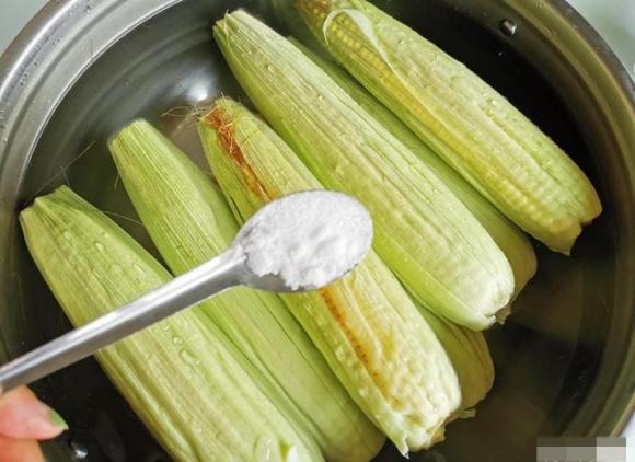 Khi nước đã sôi, thêm một ít muối và baking soda vào nồi, sau đó khuấy đều và cho ngô vào.