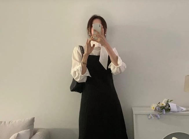 Sự kết hợp giữa sơ mi trắng và đầm không tay tạo nên một set đồ vô cùng thanh tao và sang trọng.