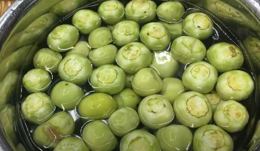 Khi làm cà muối, bạn nên phơi cà dưới nắng cho héo bớt rồi cắt cuống, ngâm cà trong nước khoảng 1 tiếng.