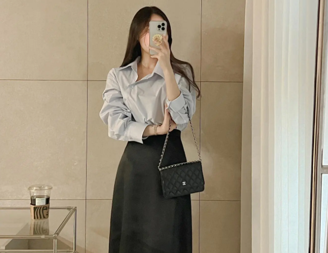 Áo sơ mi màu xanh pastel và chân váy đen dáng suông đầy trẻ trung, ngọt ngào.