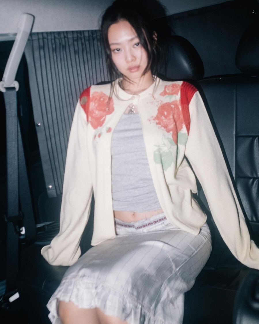 Cô chọn áo cardigan  đến từ Molly Goddard khoác ngoài tank top xám cùng tông với chân váy midi của Cormio