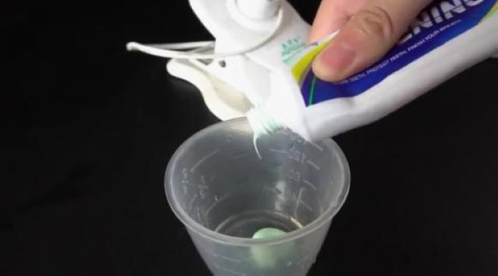 Chuẩn bị một cái bát/cốc, đổ một lượng kem đánh răng vào hộp.