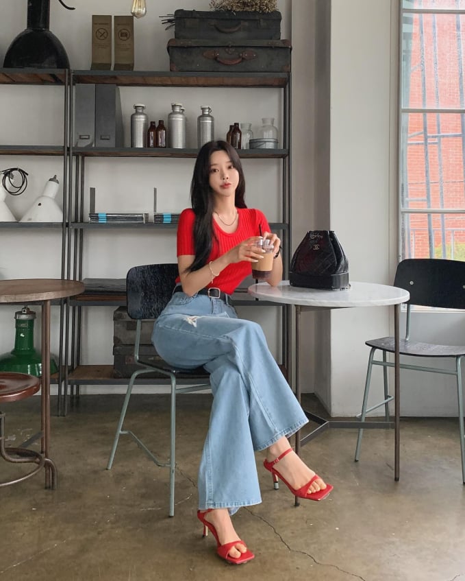 Chị em hãy nắm bắt xu hướng thời trang mùa hè với set đồ gồm áo dệt kim màu đỏ, quần jeans ống rộng và sandal cao gót, chiếc thắt lưng da tông màu đen.    