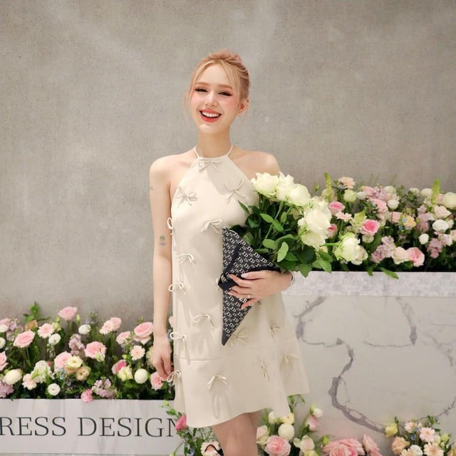 Cô tiểu thư tóc vàng thả dáng nhẹ nhàng trong em váy cổ yếm đính nơ điệu đà.