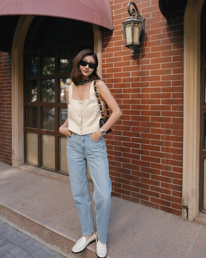 Chị em sẽ có vẻ ngoài vừa thanh lịch, vừa trẻ trung khi kết hợp áo gile với quần jeans xanh, ống đứng. 