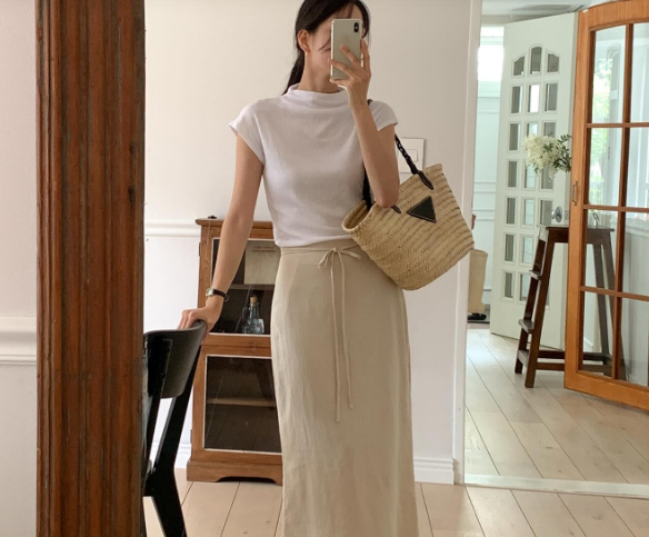 Áo thun trắng và chân váy vải thô đũi giúp người mặc ghi điểm phong cách.