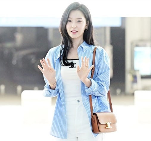 Set áo hai dây trắng và quần jeans xuyệt tông của Kim Ji Won trở nên nổi bật hơn nhờ chiếc áo sơ mi kẻ sọc khoác ngoài. 