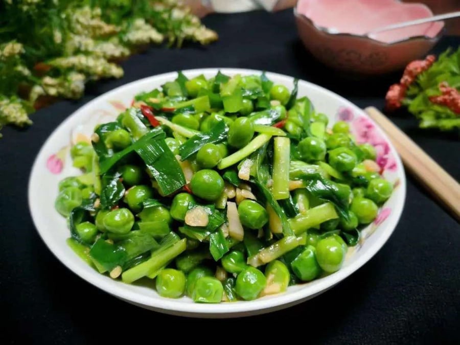 Món đậu Hà Lan xào tỏi tây sau khi hoàn thành có vẻ ngoài bắt mắt, với màu xanh tươi của đậu và màu trắng xanh của tỏi tây