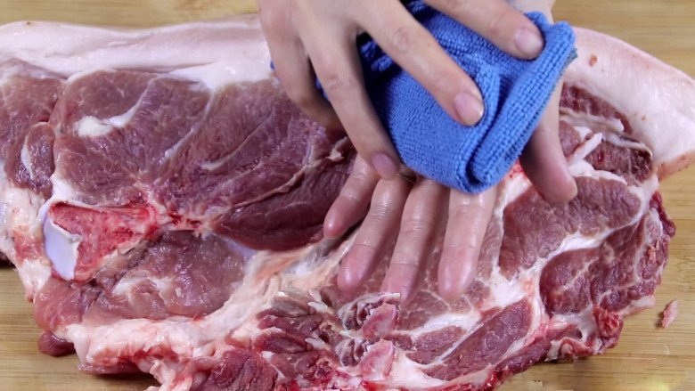 Người bán hàng dùng giẻ lau để làm khô miếng thịt