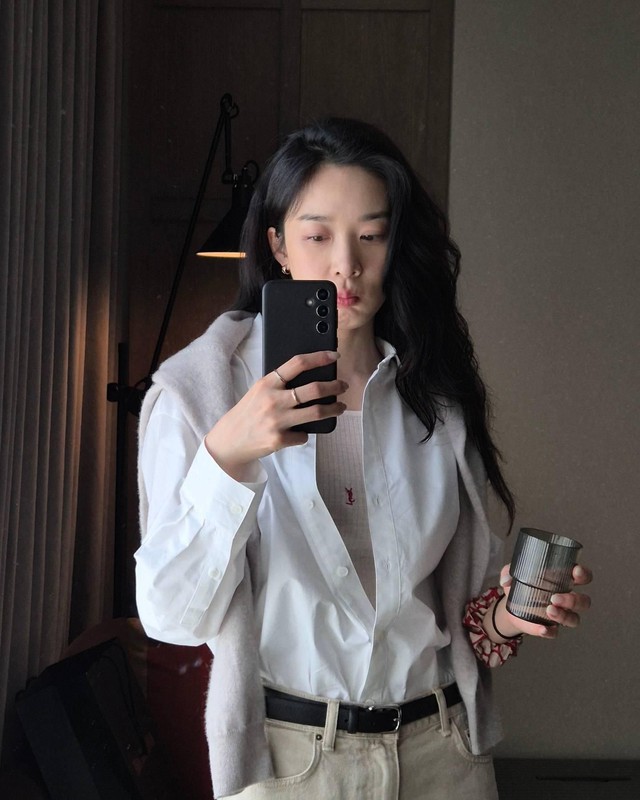 Lee Chung Ah diện bộ độ thanh lịch với áo dệt kim và quần jeans trắng ghi điểm ở sự năng động thì áo sơ mi, thắt lưng lại mang đến nét thanh lịch.    