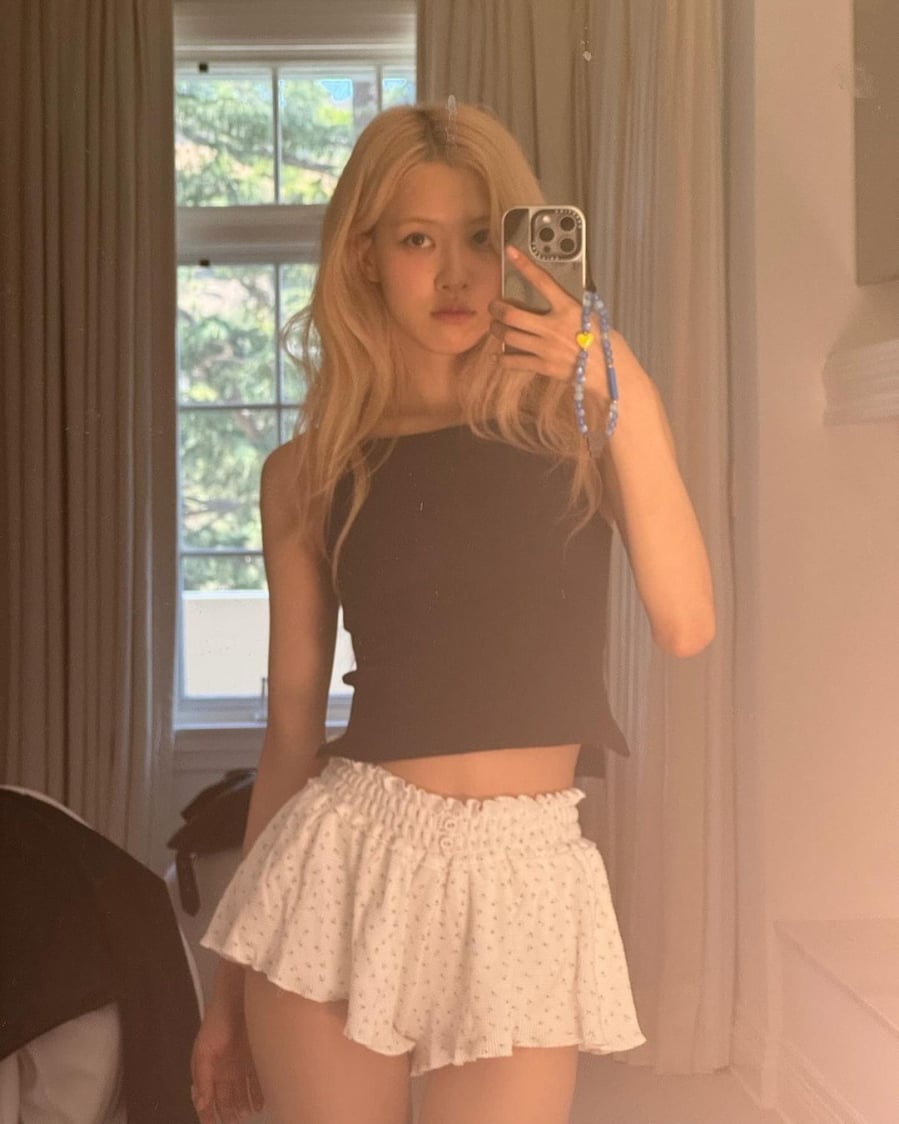Rosé (BLACKPINK) diện c đồ ngủ gồm áo hai dây dáng ôm màu đen và quần shorts họa tiết hoa nhí nhẹ nhàng.